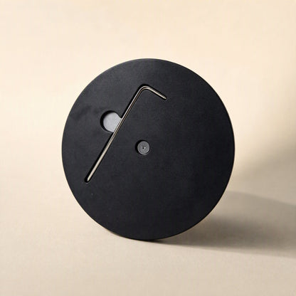 Swiveldesk – Underside of the round black base with an allen key stored in a recessed slot and a bottom screw