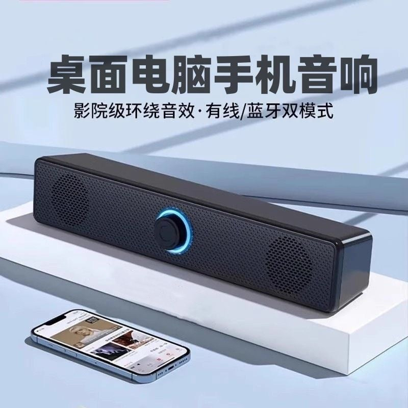 Wavecrest Small Desktop Speaker, a black bar with glowing blue knob, on a white shelf beside a smartphone