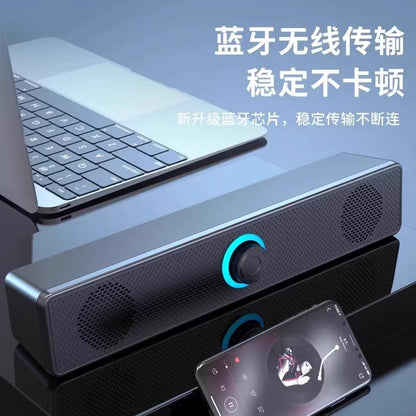 Wavecrest – Slim black speaker bar with blue glowing dial on a desk next to a laptop, a phone playing music in front