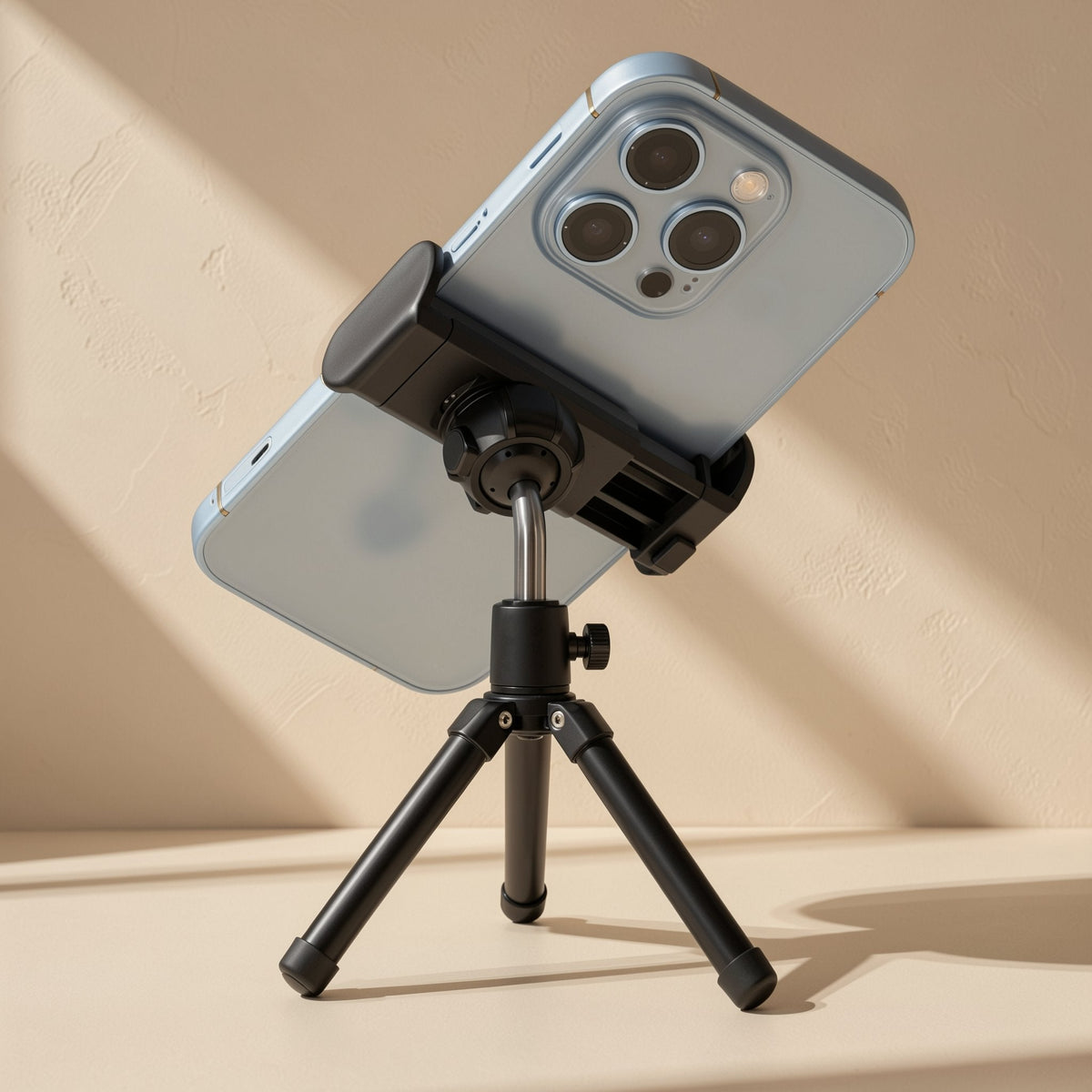 Hoverhold Overhead Phone Stand – light blue phone gripped in a black clamp on a short tripod, angled toward the camera