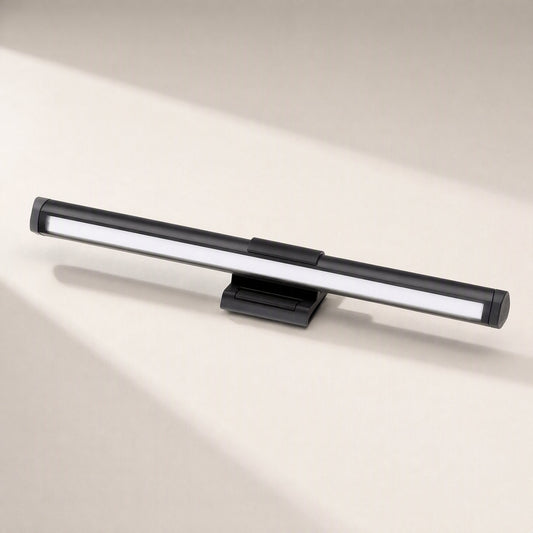 Taskglow – Black light bar and clip seen from the front, with a diffused white LED strip on a cream background