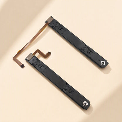 Railglide – Two black slide rails with flex cables laid out diagonally in an L shape on a cream surface