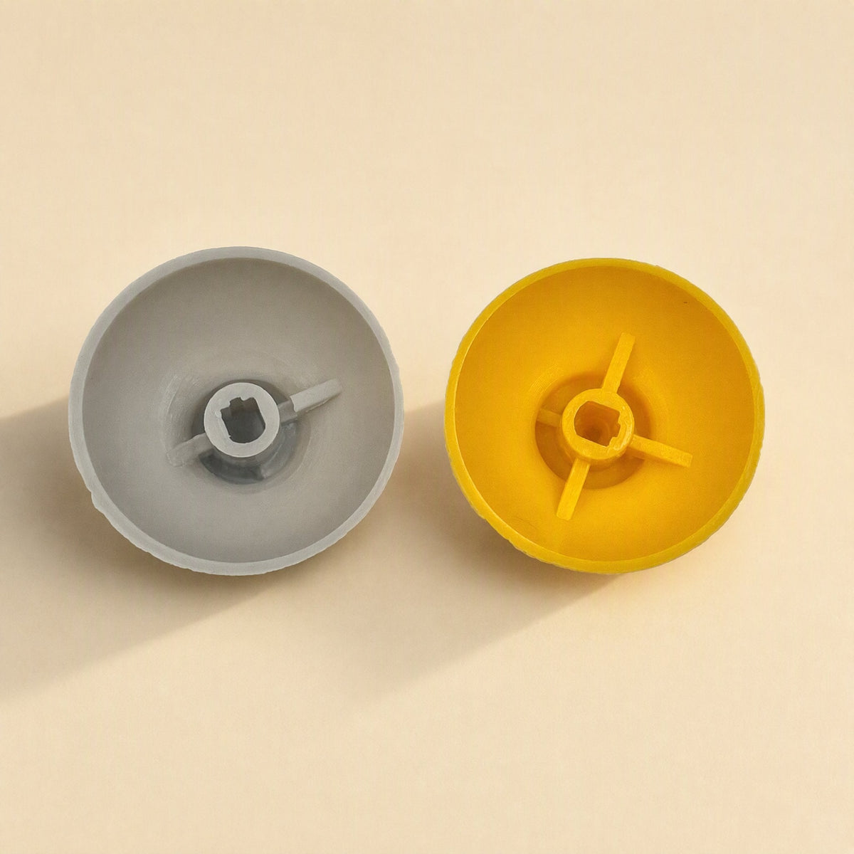Rockergrip – Underside view of gray and yellow caps showing the square center socket and three support fins