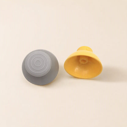 Rockergrip Plastic Rocker Cap – gray cap top-up beside a yellow cap tilted to show its hollow interior and center post
