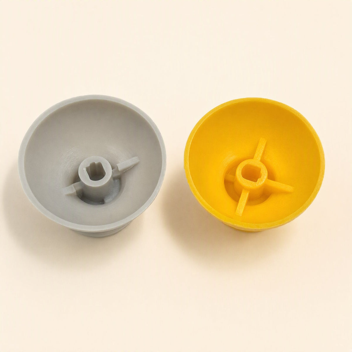 Rockergrip Plastic Rocker Cap – close view of the hollow undersides of the gray and yellow caps with square sockets and ribs
