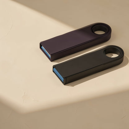 Metalbyte – Two metal flash drives in dark purple and black lying flat, blue USB connectors facing the viewer