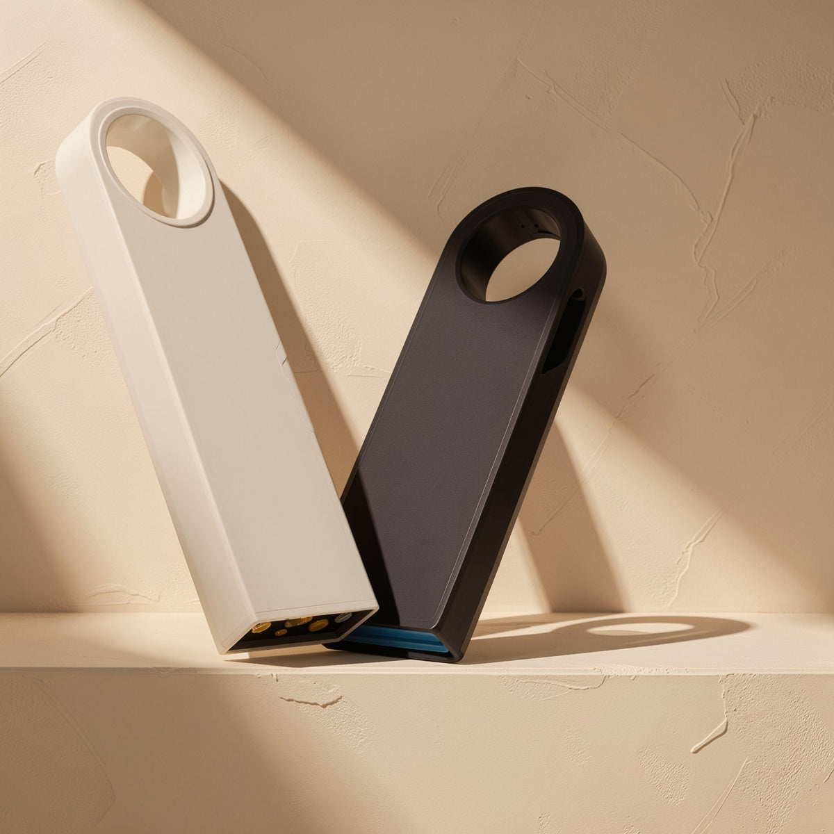 Metalbyte – White and black metal USB drives leaning against each other, showing gold contacts and a blue USB connector