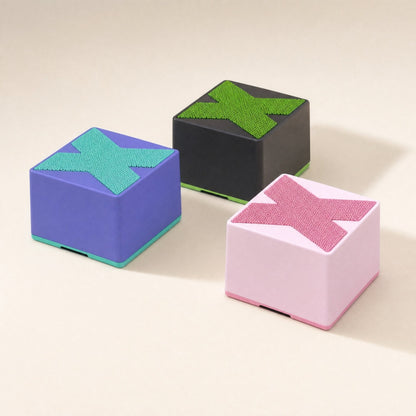 Meshsound – Purple, black and pink cube speakers with X mesh tops and colored base trims, seen from a low angle