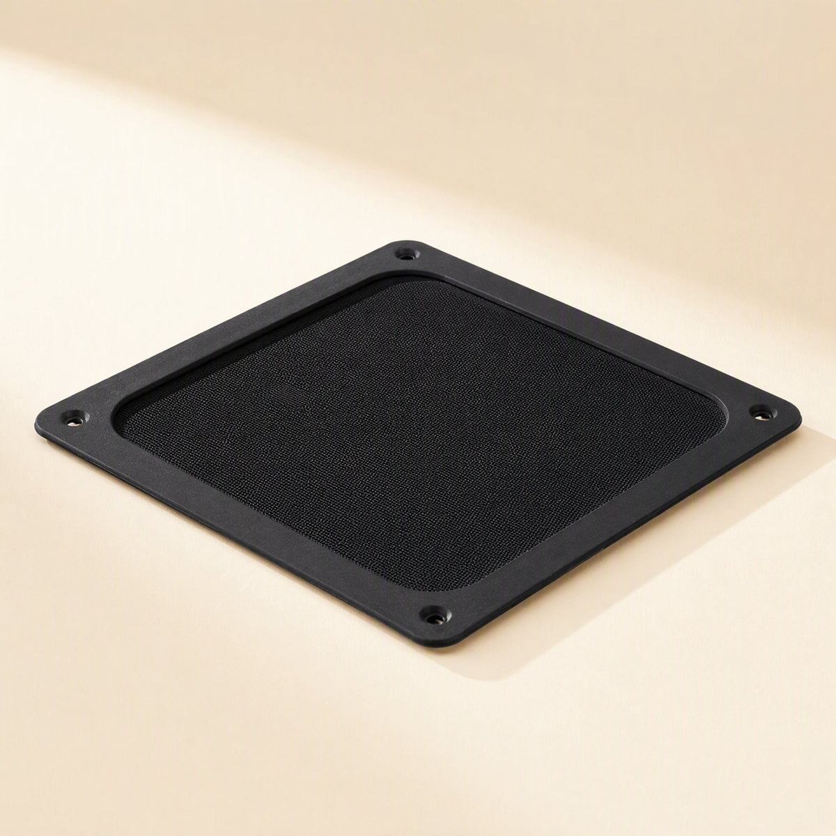 Dustflow – Black square filter lying flat at an angle, showing fine mesh centre and four corner holes
