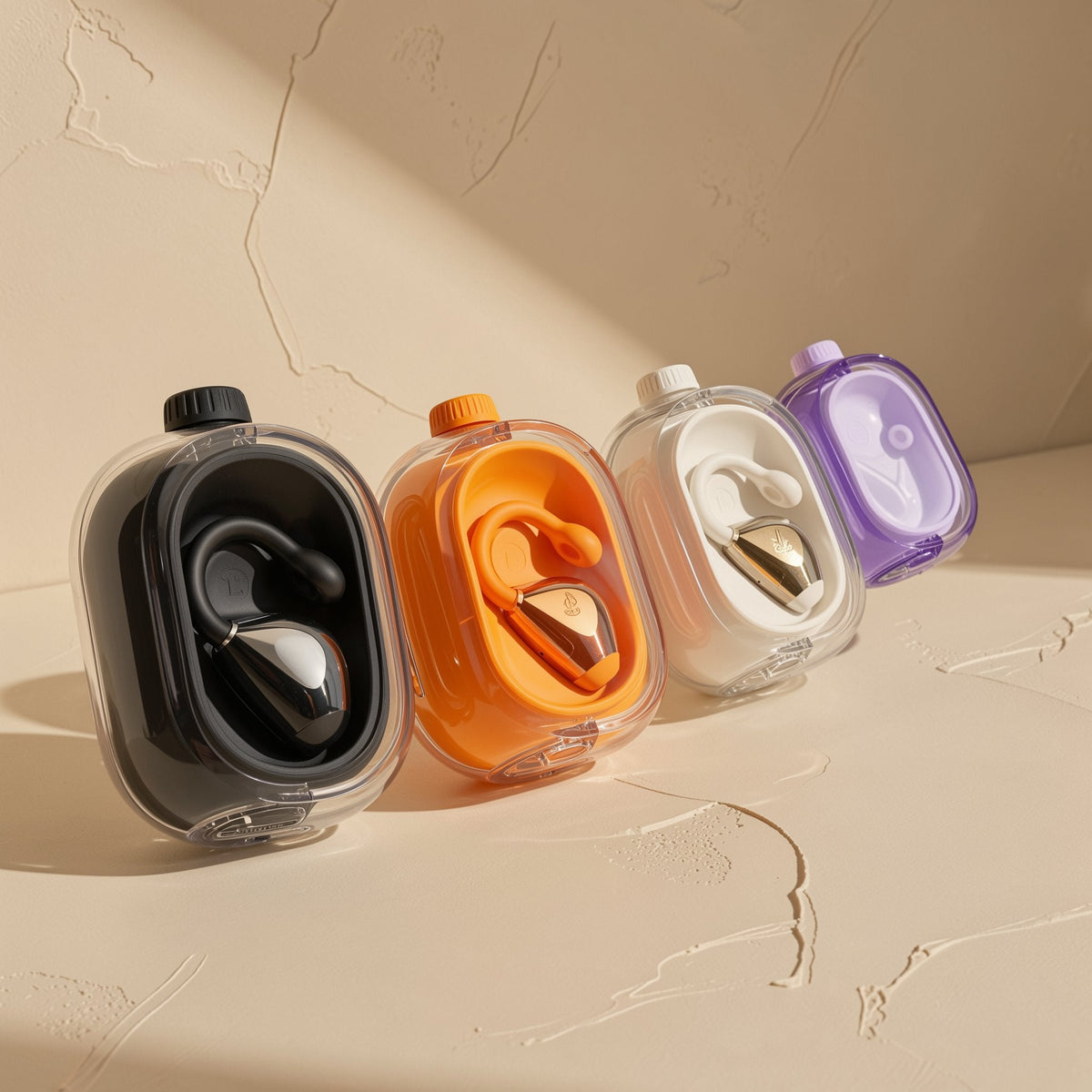 Cliphear – Four earphone cases in black, orange, white and purple, each holding a clip-on earphone, in a diagonal row