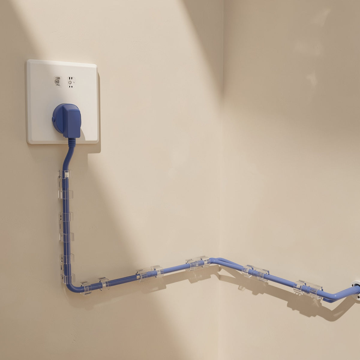 Stickcord cable organizer clips holding a blue power cord along a beige wall from an outlet
