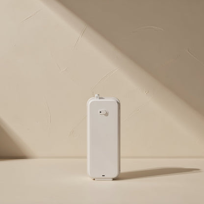 Stickcord – Back of a white rectangular device standing upright on a beige surface against a plaster wall