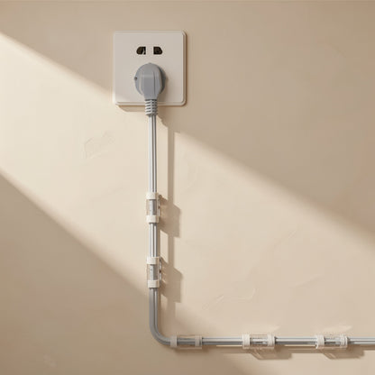 Stickcord – Gray power cord from a wall outlet run down and along the wall with clear cable clips spaced along it