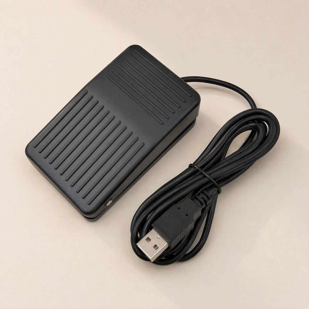 Tapstep – Top view of the black foot pedal with ribbed surface and long looped USB cable with Type-A connector