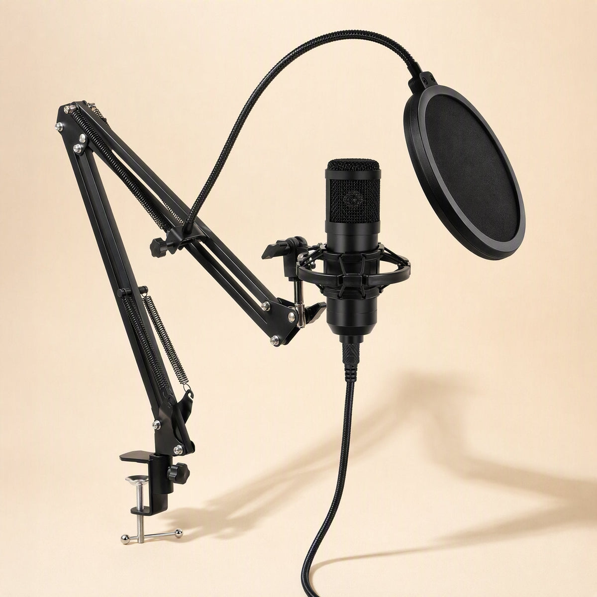 Voxblend – Black mic mounted in shock mount on a clamp-on boom arm with a pop filter and cable hanging down