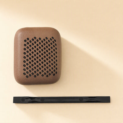 Earsoft – Single brown perforated ear pad cover beside a black plastic pry tool on a cream surface