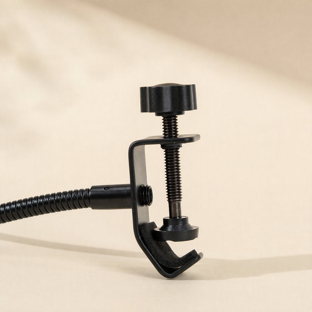 Popcatch Microphone Pop Filter – close-up of the black C-clamp with thumbscrew and gooseneck joint on a cream background