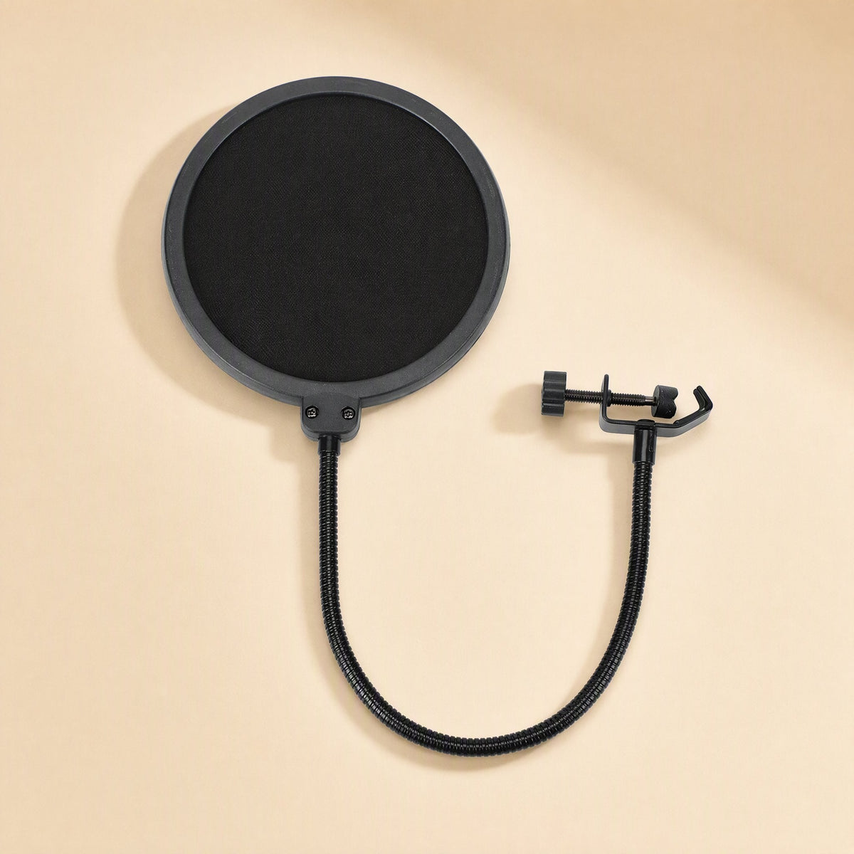 Popcatch Microphone Pop Filter – black round pop filter with gooseneck arm curving to a clamp, laid flat on a beige surface