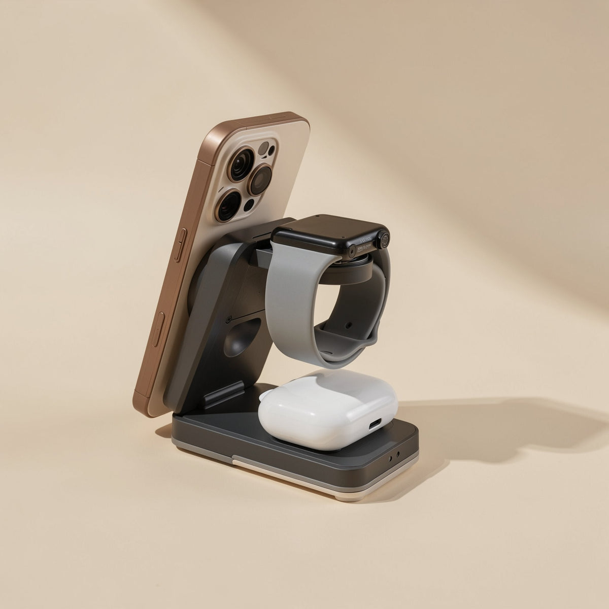 Dark gray Magperch charging stand with a copper phone attached magnetically, a watch and a white earbuds case