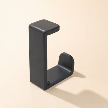 Softperch – Black L-shaped desktop headphone hanger with a flat top clamp and curved cradle, three-quarter view