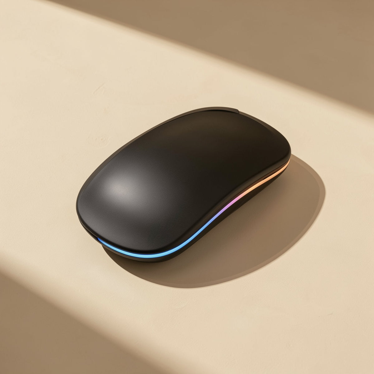 Roamclick Silent Wireless Laptop Mouse in matte black with a glowing rainbow LED strip, in warm window light