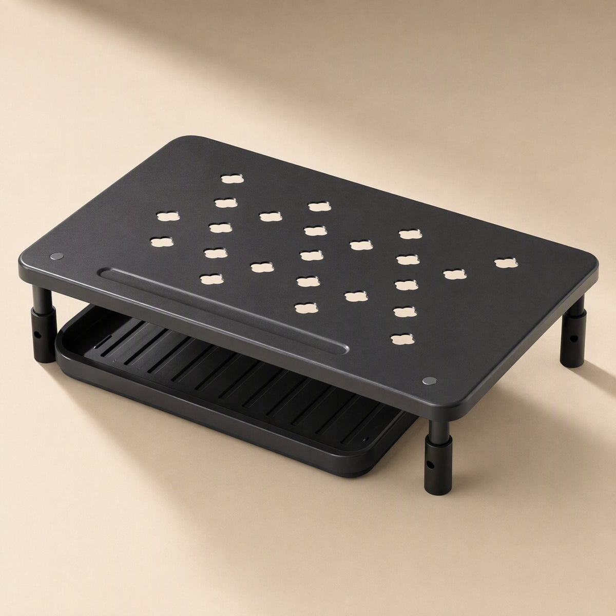 Risecrest – Black riser from above showing the perforated top, slot groove and open tray beneath on a beige background