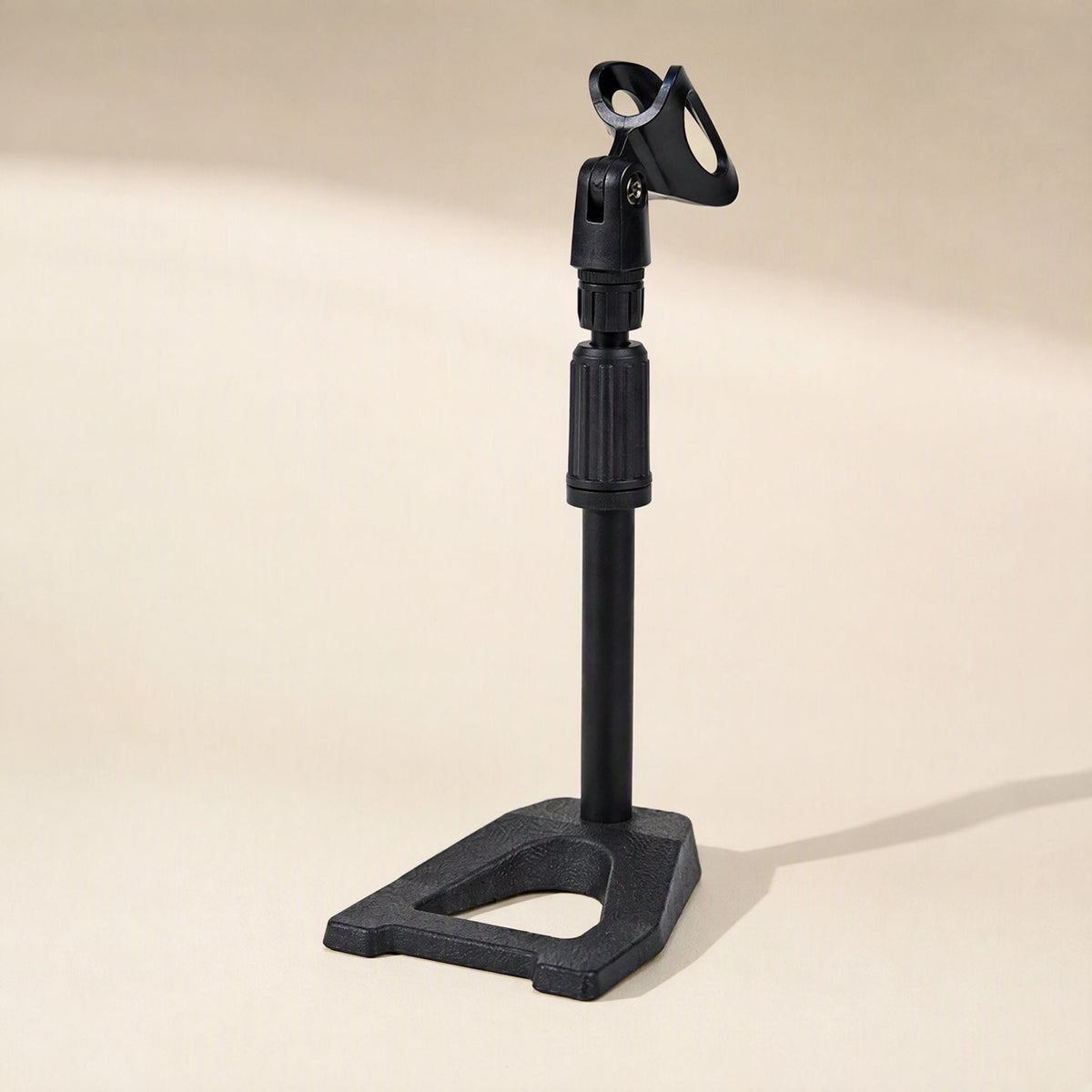 Voicepost Desktop Microphone Stand in black with a cast base and clip, on a cream background